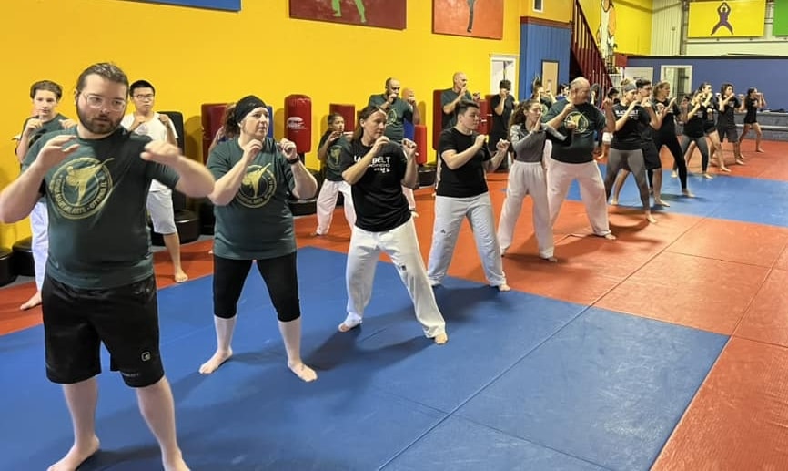 A class of students facing an instructor in the same ready position